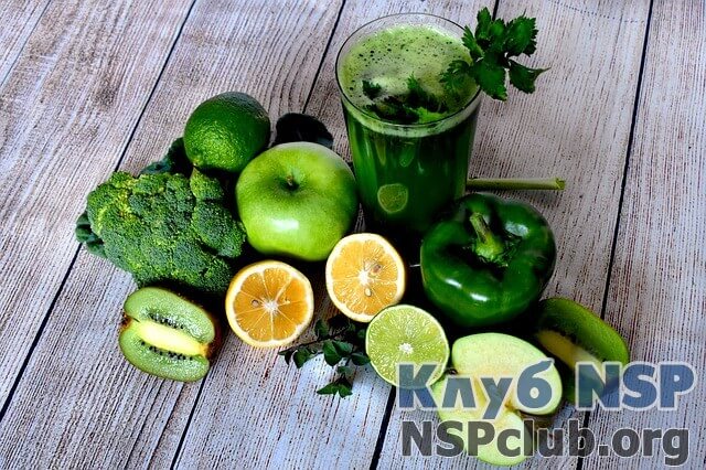 Зеленые овощи, зеленый смузи в стакане, на сером столе